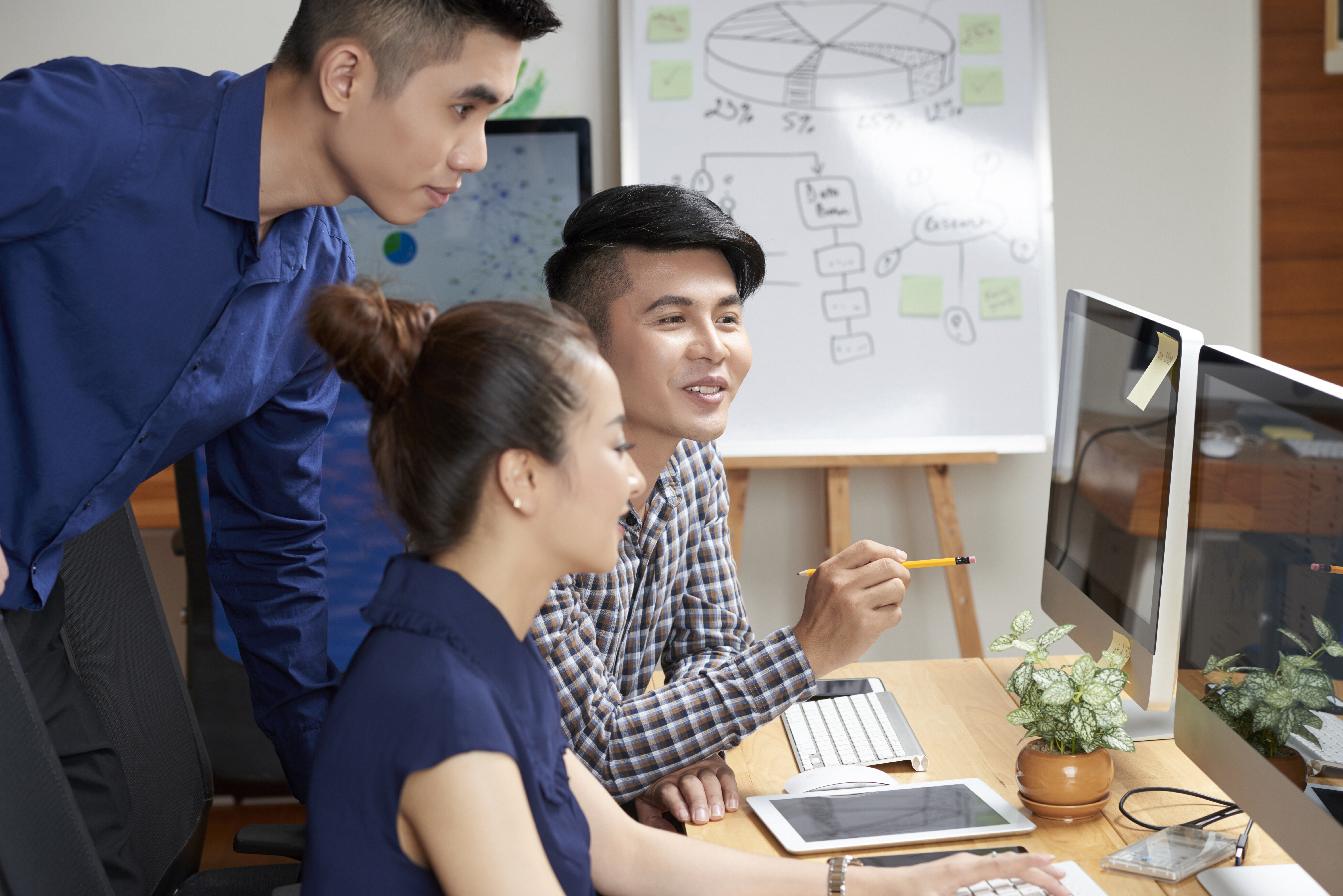 Positive Asian business team discussing possible ways of project development at meeting